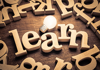 Wood blocks spelling out the word "learn" with a light bulb in the middle.