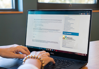 An individual completing an online form on a laptop