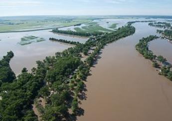 Water level of a river rose over the tops of its banks, into the surrounding fields